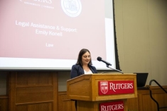 woman in a suit speaking behind a podium