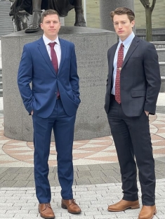 Two men in suits posing for a photograph