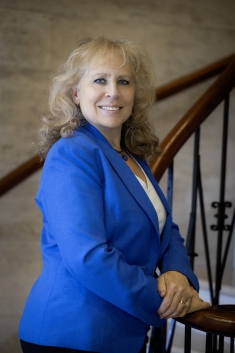woman smiling in blue blazer on staircase