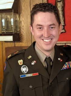 man in green military uniform smiling