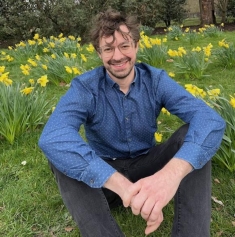 man sitting on grass posing for a photograph