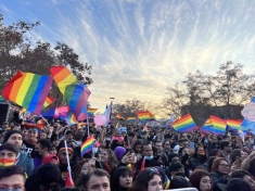 group of people holding rainbow LGBTQIA+ flags
