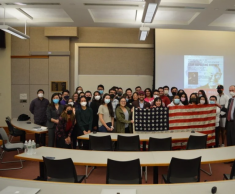 Group of people holding an American flag posing for a photograph