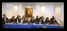 group of men and women seated next to each other at long rectangular table