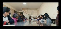 Group of women sitting on both sides of a long rectangular table