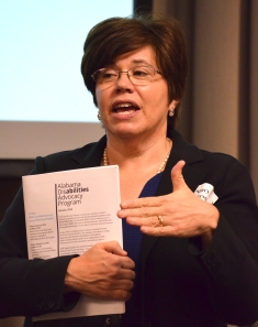 woman holding paper and speaking
