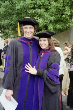 man and women in black and purple cap and gowns