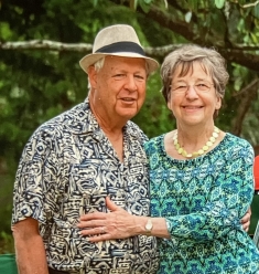 man and woman standing next to each other in colorful print shirts