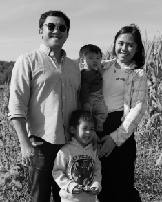 black and white image of mom, dad and two boys in family photo