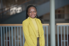 woman in yellow blazer and turtleneck smiling 