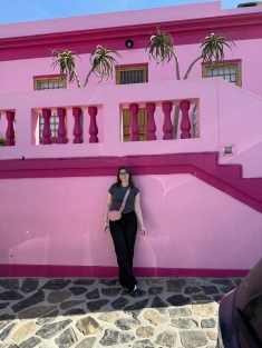 woman standing in front of pink home