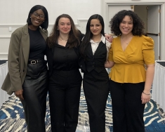 four women standing next two each other and smiling