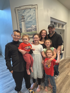 mom, dad, and five children smiling in home
