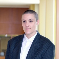person in white blouse and dark blue blazer grinning