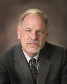 man in suit in front of brown background