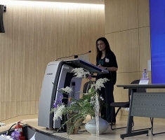 woman dressed in black speaking at podium in front of classroom