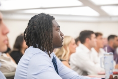 man in shirt and tie looking forward in classroom