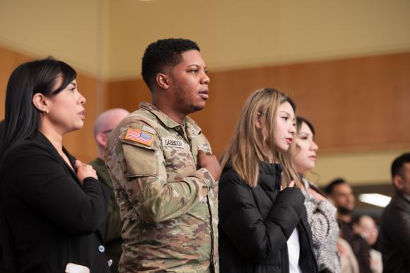 Soldier takes raises hand and takes Oath with other new citizens