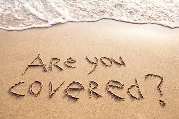 'Are you covered?' written in sand