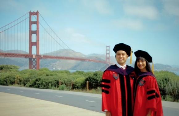 married couple in law school hoods in front of Golden Gate Bridge