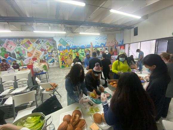 Students & staff making 1200 ham sandwiches for migrants at the border.
