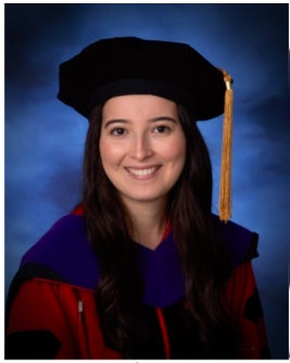 woman smiling in law school hood and graduation cap