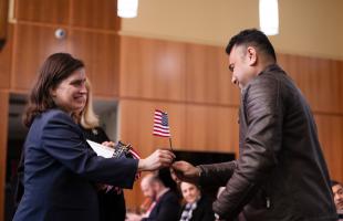 woman hands US flag to man