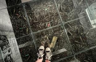 feet standing on top of glass enclosure with bullet casings underneath in cuba