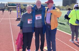 wom and two men on running track