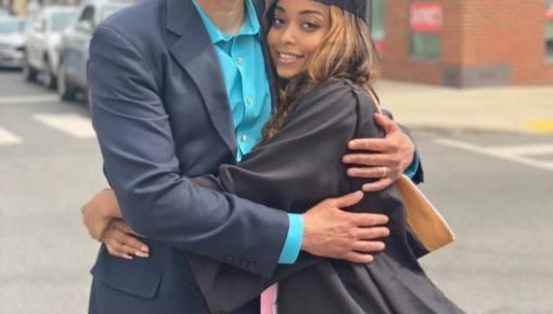 man hugging daughter in graduation gown
