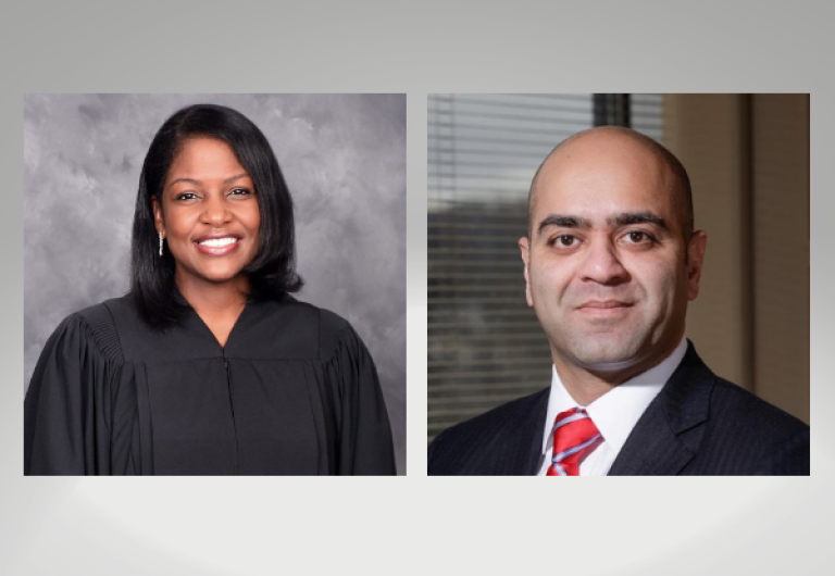 woman smiling in judge's robe and man smiling in suit